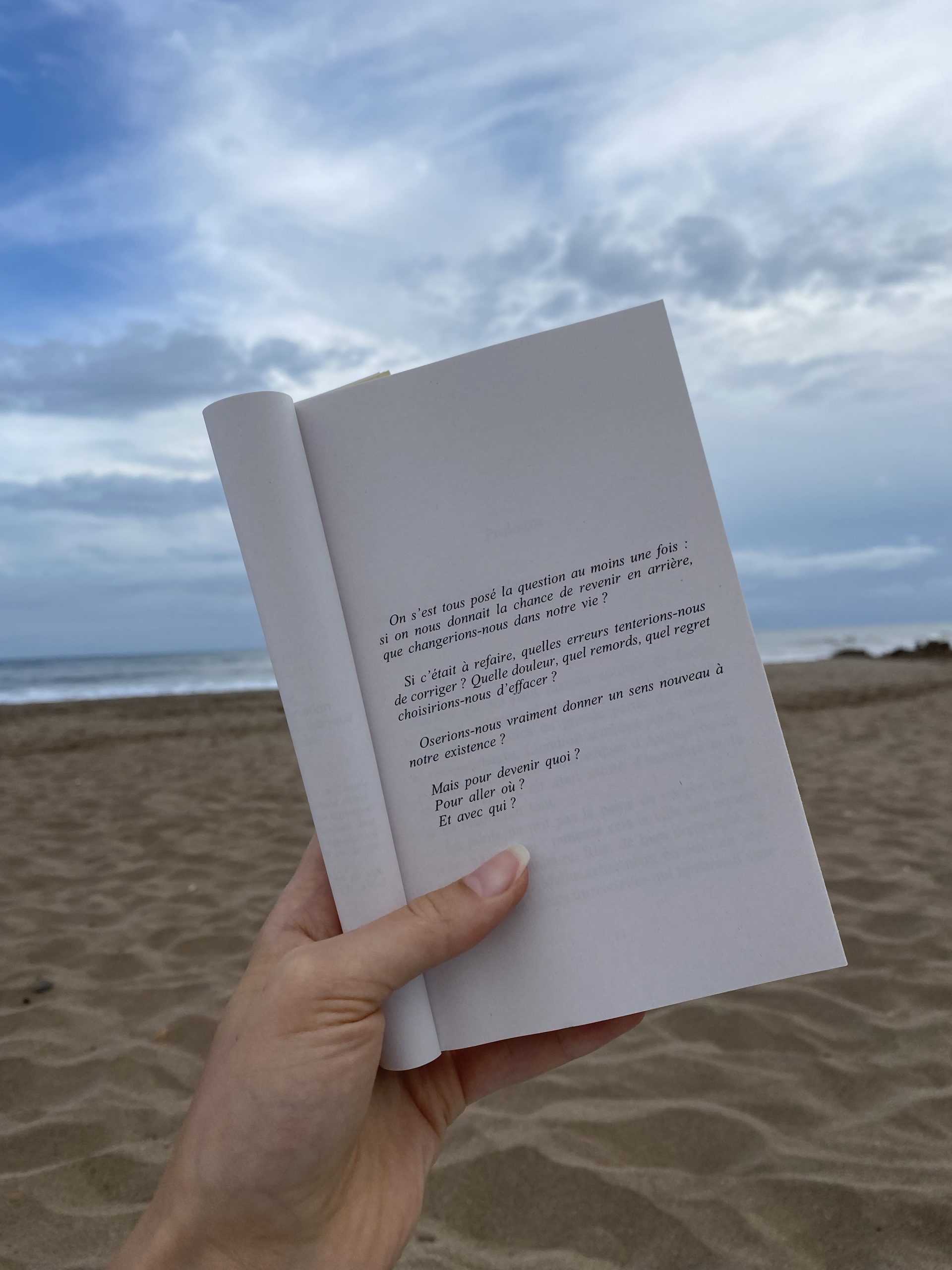 une page de livre tenue face à la mer